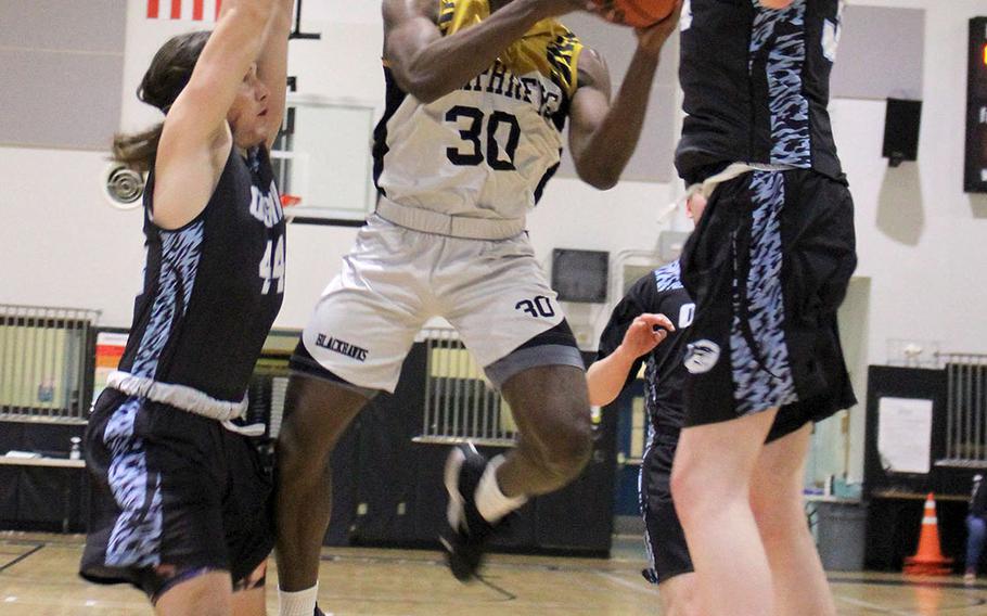 Humphreys Black's Melvin Wrightsil goes up between Osan Black defenders for a shot during Friday's DODEA-Korea boys basketball game. The Blackhawks routed the Cougars 101-69.