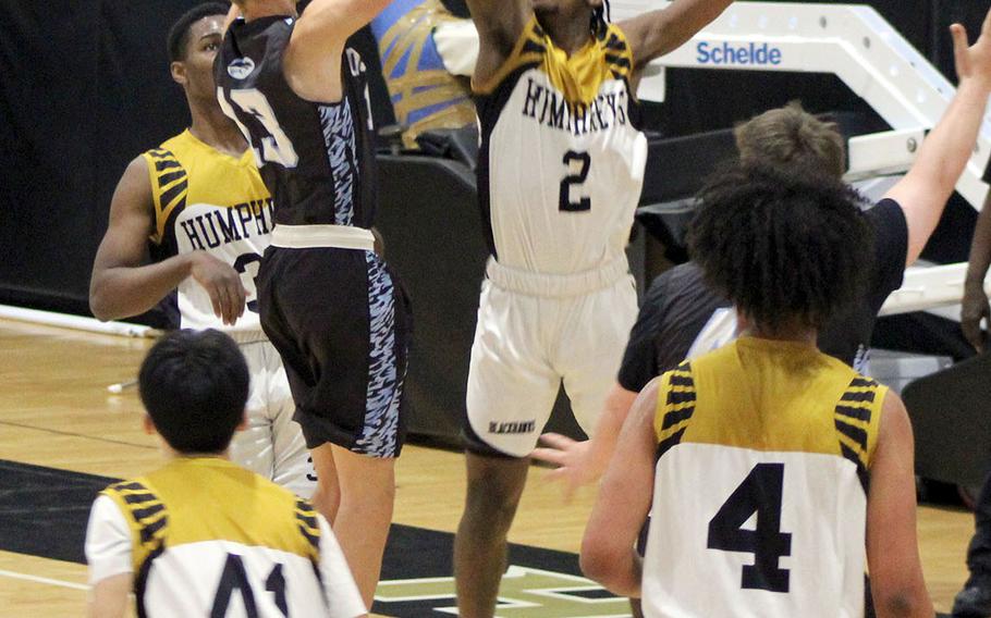 Humphreys Black's Myles Johnson goes up to block a shot by Osan Black's Brandon Edmunds during Friday's DODEA-Korea boys basketball game. Johnson scored a school-record 55 points as the Blackhawks routed the Cougars 101-69.