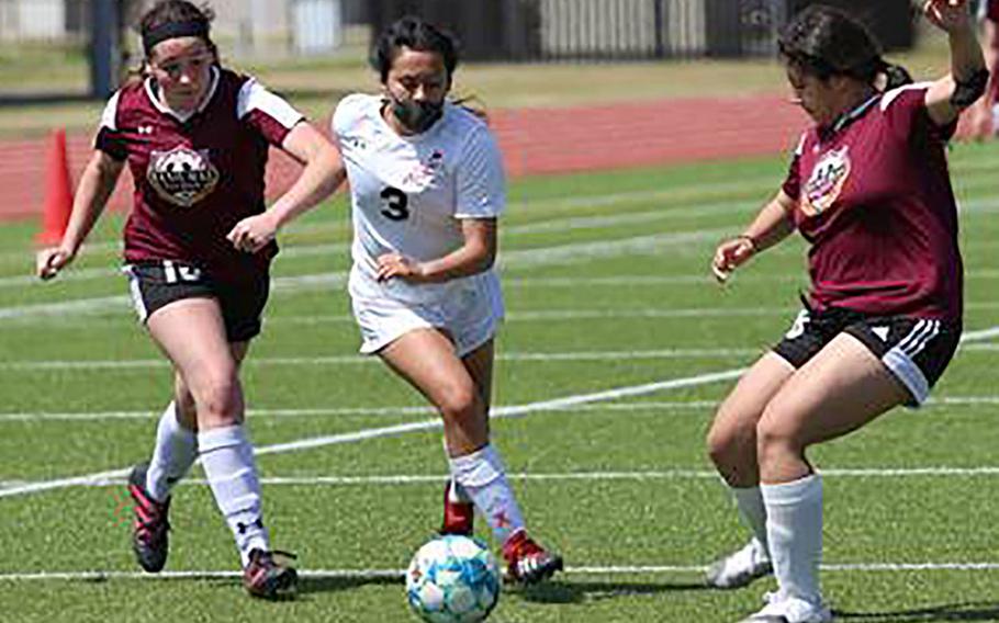E.J. King's Alyssa Garcia dribbles between two Matthew C. Perry defenders during Saturday's DODEA-Japan girls soccer matches. The Cobras swept two matches from the Samurai.