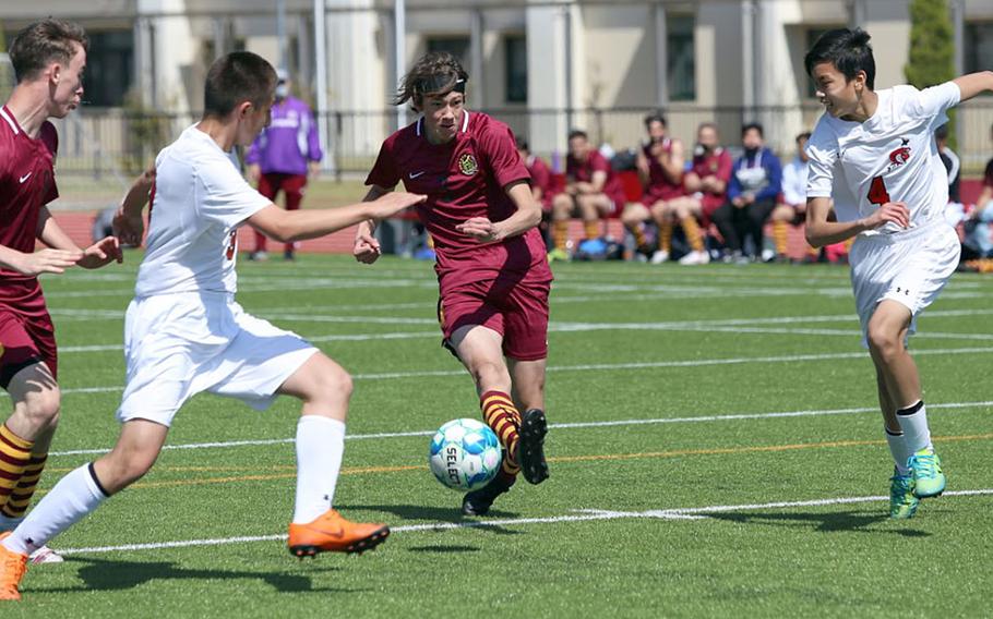 Matthew C. Perry's Gage Behnken dribbles between E.J. King defenders during Saturday's DODEA-Japan boys soccer match. The Samurai swept two matches from the Cobras.