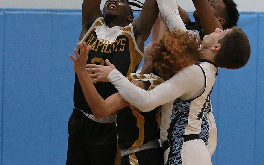 Humphreys Black's Myles Johnson reaches above a scrum of Osan Blue opponents and Blackhawks teammates for one of his 18 rebounds during Saturday's DODEA-Korea basketball game. Humphreys Black won 65-26.