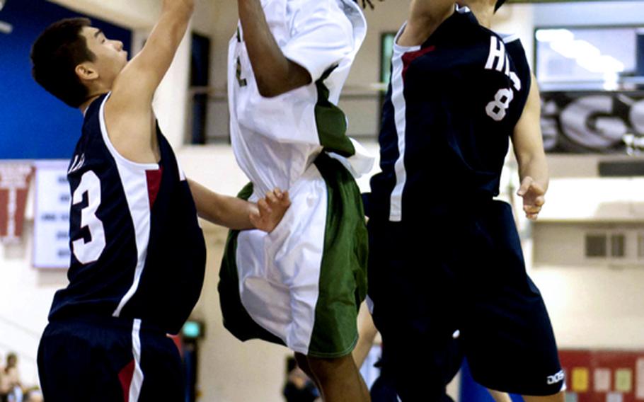 Kubasaki guard C.J. Crenshaw has his shot slapped away by Hong Kong International defender Adam Xu (8) while Hong Kong's Lawrence Lee defends during Saturday's boys championship game in the 41st Hong Kong International School Holiday Basketball Tournament. Kubasaki edged Hong Kong 76-75.