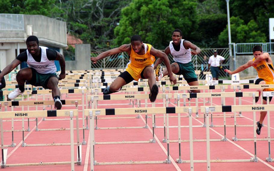 Competitors in the boys 110 meter hurdles leap over the hurdles and race towards the finish line Friday in Chatan, Okinawa. Jalah Patten from Kubasaki High School won the race in 16.02 seconds.