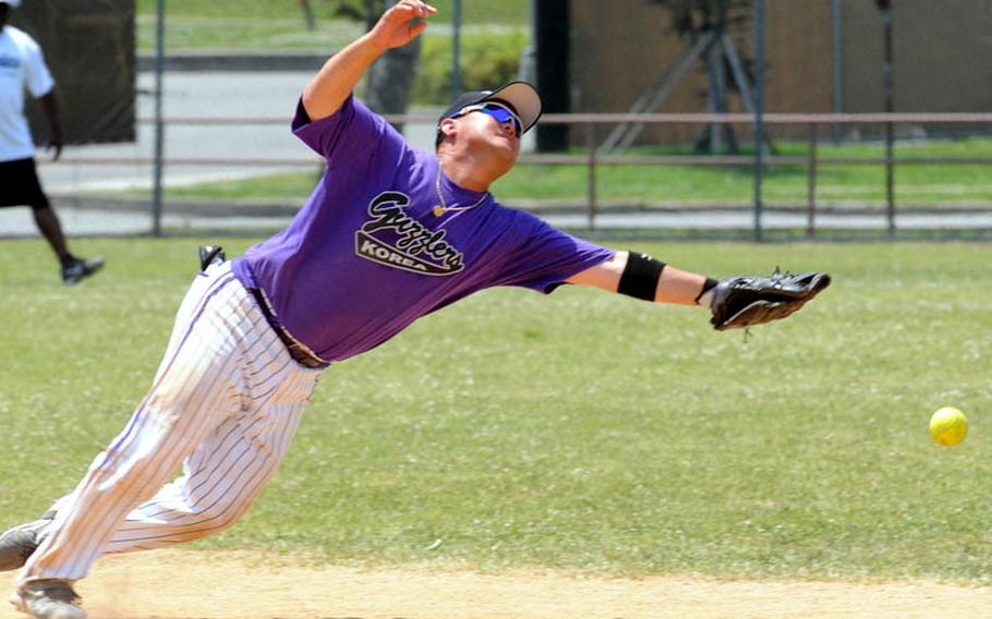 Second baseman Lance Nakayama of International Guzzlers stretches in vain for a Daegu/Area IV ground ball during Sunday&#39;s knockout bracket game in the men&#39;s A double-elimination playoff game in the 21st Pacificwide Open Interservice Softball Tournament at Field 1, FourPlex at Lombardo Field, South Post, Yongsan Garrison, South Korea. Guzzlers rallied to eliminate Daegu 23-20.