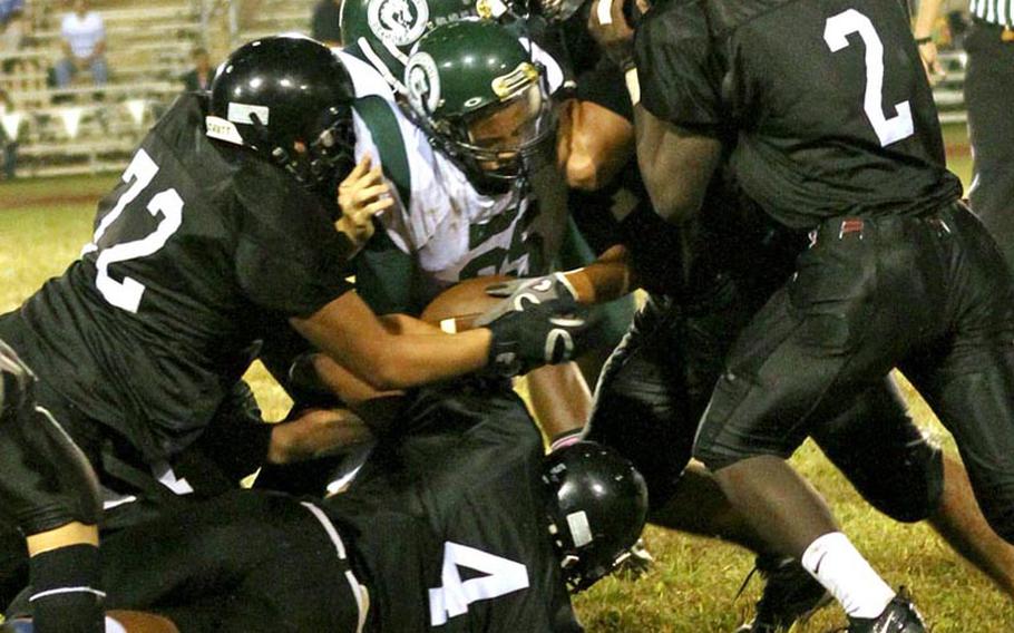 Kubasaki Dragons ball carrier Jace Johnson  is surrounded by Zama American Trojans defenders Gabriel Malate, from left, Holden Limas, David Coleman and Mitchell Harrison during Saturday's interarea high school football game at Zama American High School, Japan. Kubasaki won 48-9, improving to 3-0 in interarea play this season.