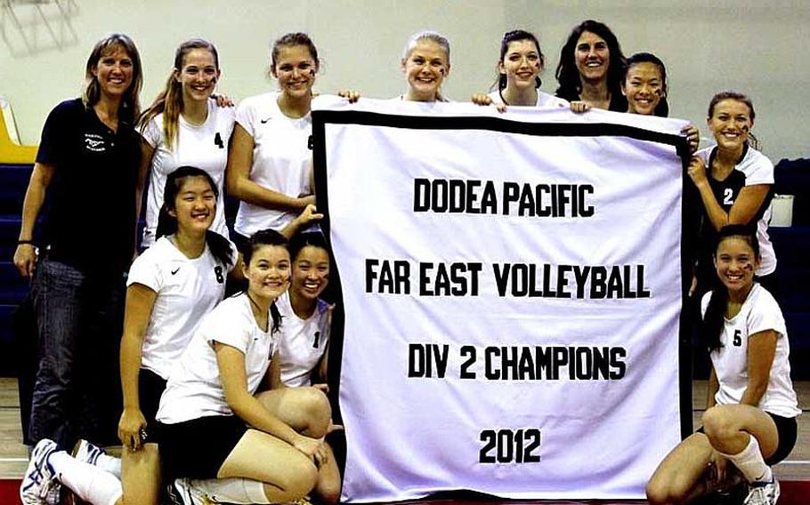 Morrison Academy Mustangs coaches and players gather around the title banner after Friday's championship match in the Far East High School Girls Division II Volleyball Tournament at Kelly Fitness & Sports Center, Camp Walker, South Korea. Morrison defended its championship 25-6, 25-15, 25-11 over host Daegu High.