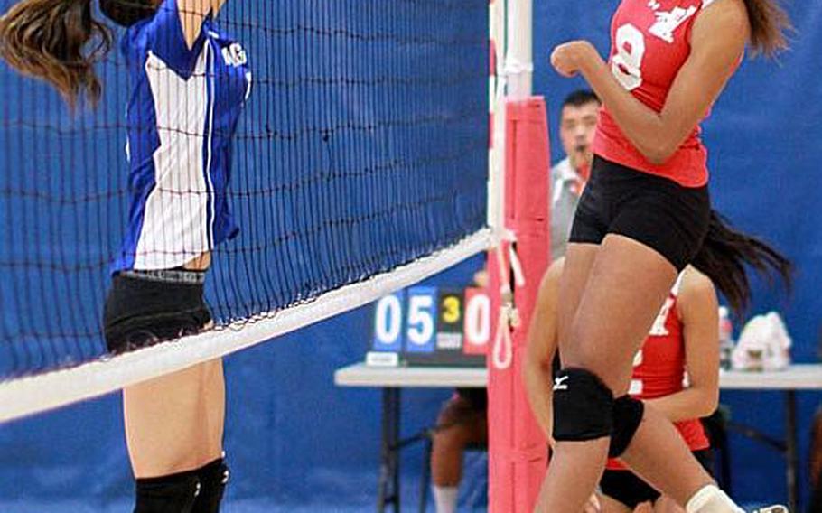 Nile C. Kinnick Red Devils' Mashiya McKinney hammers a spike kill through the block of Isabelle Charley of Christian Academy Japan Knights during Friday's semifinal match in the Far East High School Girls Division I (large schools) Volleyball Tournament at Charles King Fitness & Sports Center, Naval Base, Guam. Kinnick won 25-13, 25-14, 25-20 and advanced to Saturday's final against American School In Japan, which beat Seisen International of Tokyo 25-19, 25-22, 25-21. '