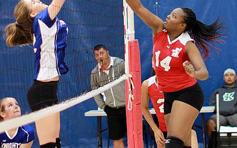 Nile C. Kinnick Red Devils' Audri Salter tries to hammer a spike kill through the block of Monica Manjarres of Christian Academy Japan Knights during Friday's semifinal match in the Far East High School Girls Division I (large schools) Volleyball Tournament at Charles King Fitness & Sports Center, Naval Base, Guam. Kinnick won 25-13, 25-14, 25-20 and advanced to Saturday's final against American School In Japan, which beat Seisen International of Tokyo 25-19, 25-22, 25-21. 