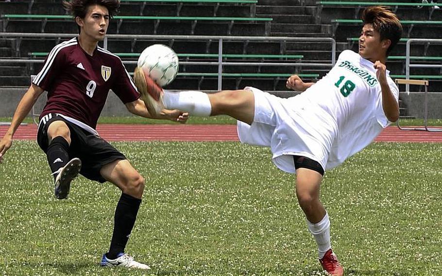 Kadena's Kian Smith and Kubasaki's Kaisei Taylor try to play the ball during Monday's round-robin match in the Far East Boys Division I Soccer Tournament, won by the defending champion Dragons 1-0.