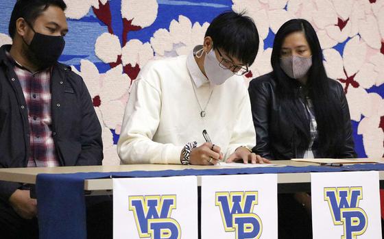 Matthew C. Perry senior Joseph Andres, center, signs an offer to play volleyball at William Penn University in Iowa.