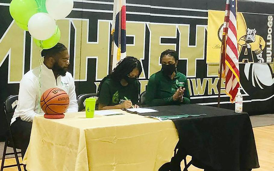 Flanked by her parents, Humphreys senior Jalynn Knight signs paperwork committing her to play basketball for Division III Wilmington College (Ohio) in the coming season.