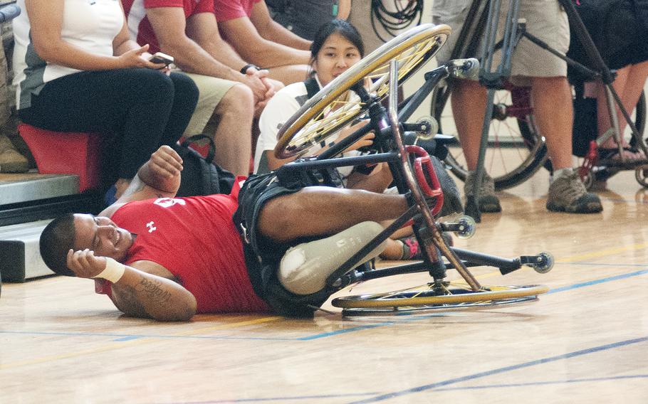Marine Alex Nguyen takes a tumble in his wheelchair Tuesday, June 23, 2015, during the Warrior Games championship wheelchair basketball matchup between Team Marine Corps and Navy at Quantico Marine Base, Va.
