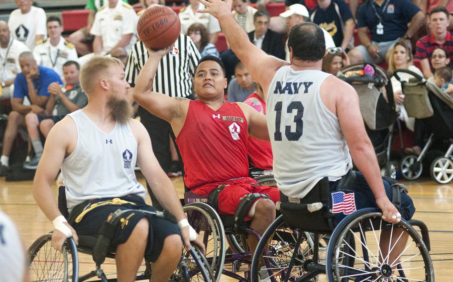 Marcus Chischilly looks to pass as Navy's Hector Varela (13) tries to block Tuesday, June 23, 2015, during the Warrior Games championship wheelchair basketball matchup between Team Marine Corps and Navy at Quantico Marine Base, Va.