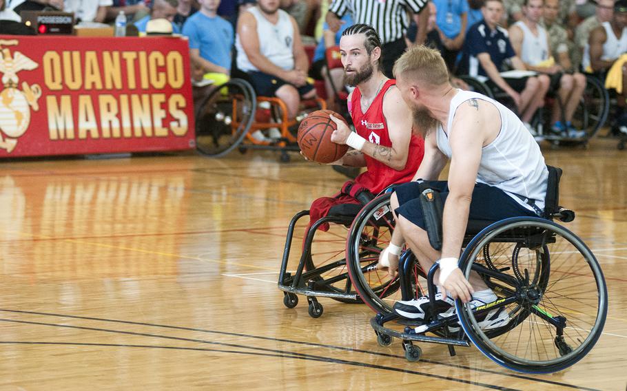 Marines point guard Ray Hennagir brings the ball up the court Tuesday, June 23, 2015, during the Warrior Games championship wheelchair basketball matchup between Team Marine Corps and Navy at Quantico Marine Base, Va. 