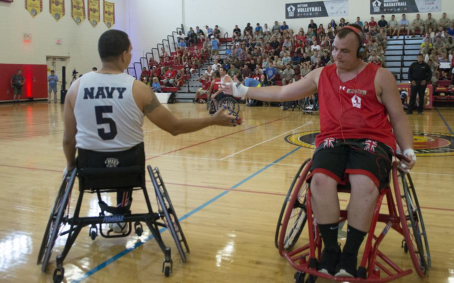 Opposing players greet each other during warm-ups for the Navy vs. Marines basketball match of the Warrior Games on June 23, 2015.