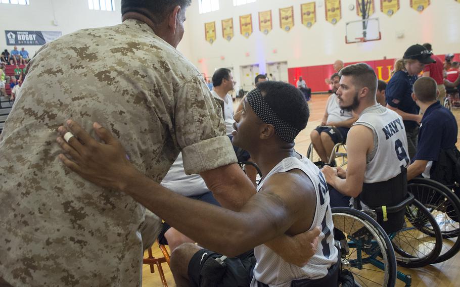 Maj. General Juan Ayala greets a Navy basketball player before the start of the Navy Vs. Marines basketball match of the Warrior Games on June 23, 2015.
