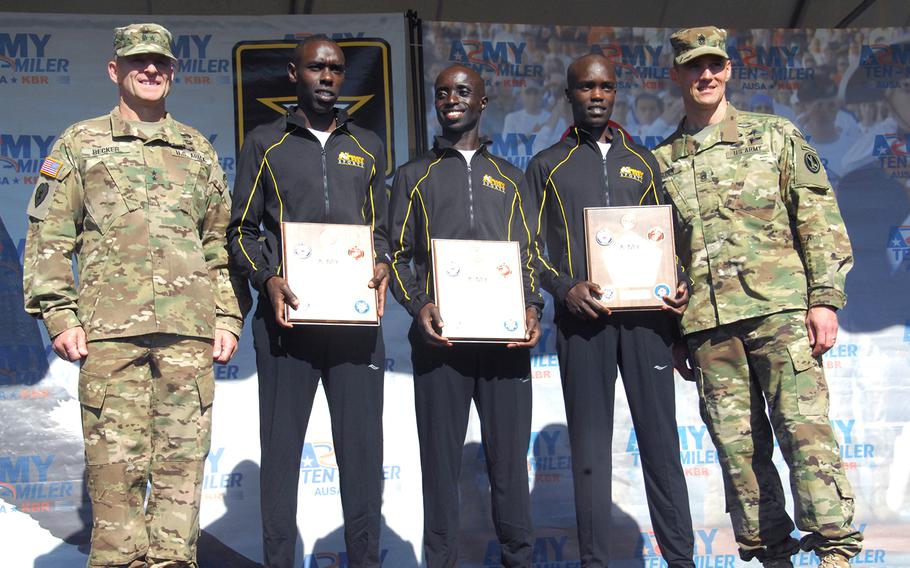 Spc. Paul Chelimo, Pfc. Nicholas Kipruto and Spc. Shadrack Kipchirchir pose with their awards for being the top finishers in the Army Ten-Miler outside the Pentagon on Oct. 11, 2015.