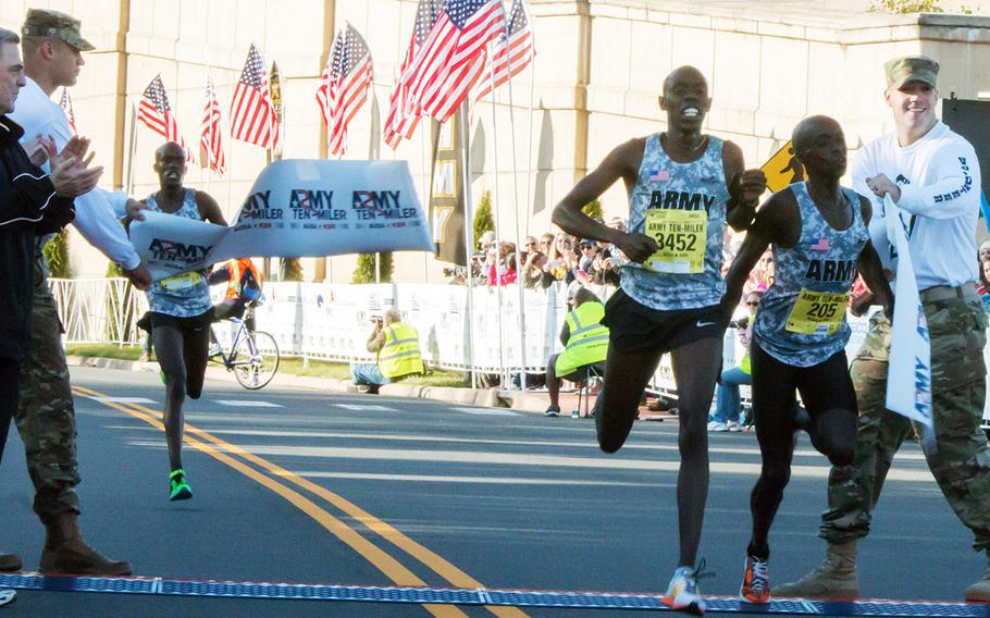Pfc. Paul Chelimo (3452) of Beaverton, Ore., crosses the finish line at the Pentagon less than a second ahead of Spc. Nicholas Kipruto of Copperas Cove, Texas, to win the 2015 Army 10-Miler. Behind them is third-place finisher Spc. Shadrack Kipchirchir of Beaverton, Ore.