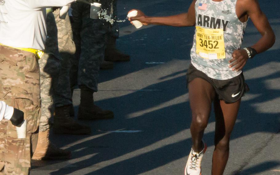 Eventual winner Pfc. Paul Chelimo grabs a drink during the 31st Army Ten-Miler in Arlington, Va. and Washington, D.C., October 11, 2015.