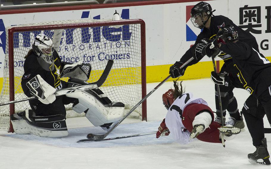 Army's defense keeps Navy's Maryann McGuire (12) from sweeping the puck past goalie Lindsey Colburn during a hockey game against a Navy team at Verizon Center in Washington, D.C., Dec. 5, 2016.