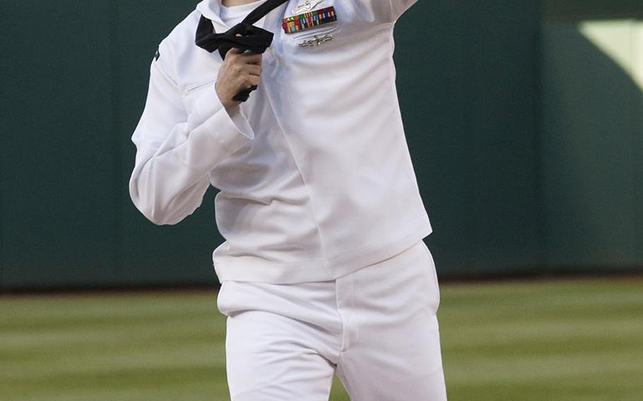 Intelligence Specialist 2nd Class Sean Grimes, Secretary of the Navy sailor of the year, winds up to deliver the ceremonial first pitch on U.S. Navy Day at Nationals Park in Washington, D.C., May 3, 2017.