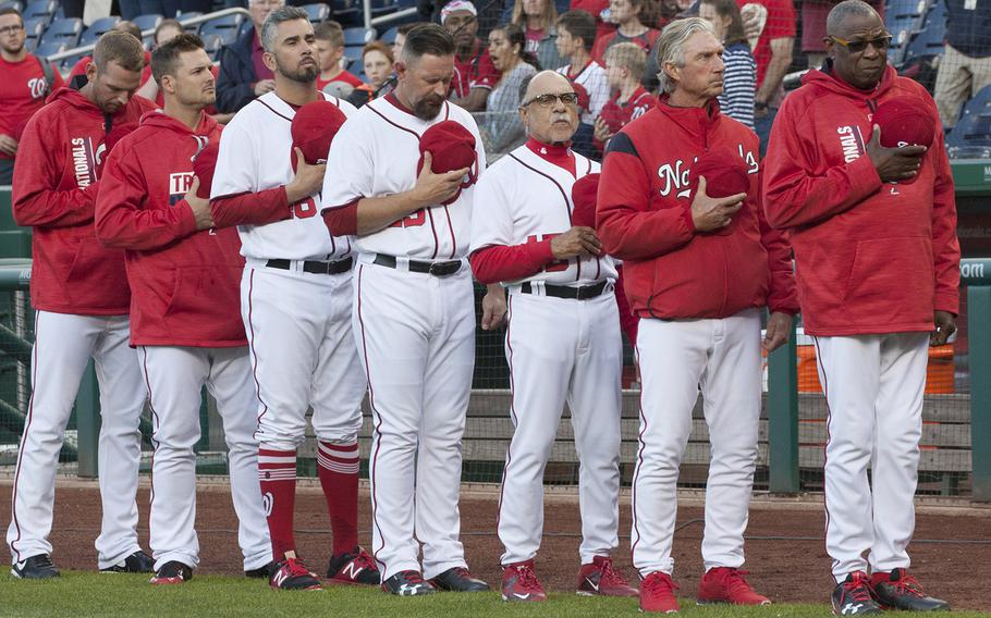 Washington Nationals manager Dusty Baker, right, and his coaches and players stand for the national anthem on U.S. Navy Day at Nationals Park in Washington, D.C., May 3, 2017.