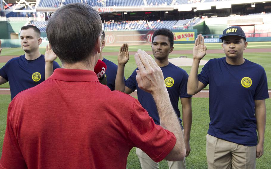 New sailors take the Oath of Enlistment from Acting Secretary of the Navy Sean Stackley on U.S. Navy Day at Nationals Park in Washington, D.C., May 3, 2017.