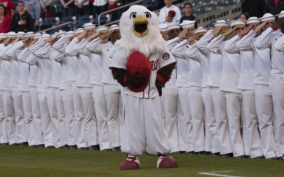 Washington Nationals mascot Screech stands with sailors during the playing of the national anthem on U.S. Navy Day at Nationals Park in Washington, D.C., May 3, 2017.