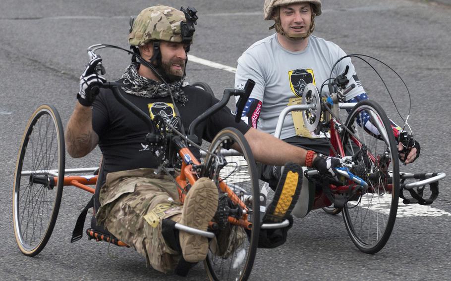 Retired Army Staff Sgt. Earl Granville, left, and retired Marine Cpl. Matthew Bradford compete in the Army 10-Miler Sunday, Oct. 8, 2017 in Washington, D.C.