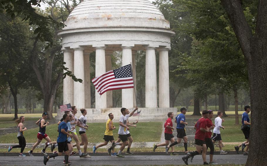 Runners in the Army Ten-Miler carry the colors past the D.C. World War I Memorial in Washington, Sunday, Oct. 8, 2017.