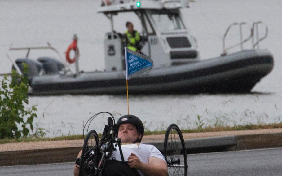 A competitor in the Army Ten-Miler in Washington, D.C., Sunday, Oct. 8, 2017 passes a police boat on the Potomac River.

