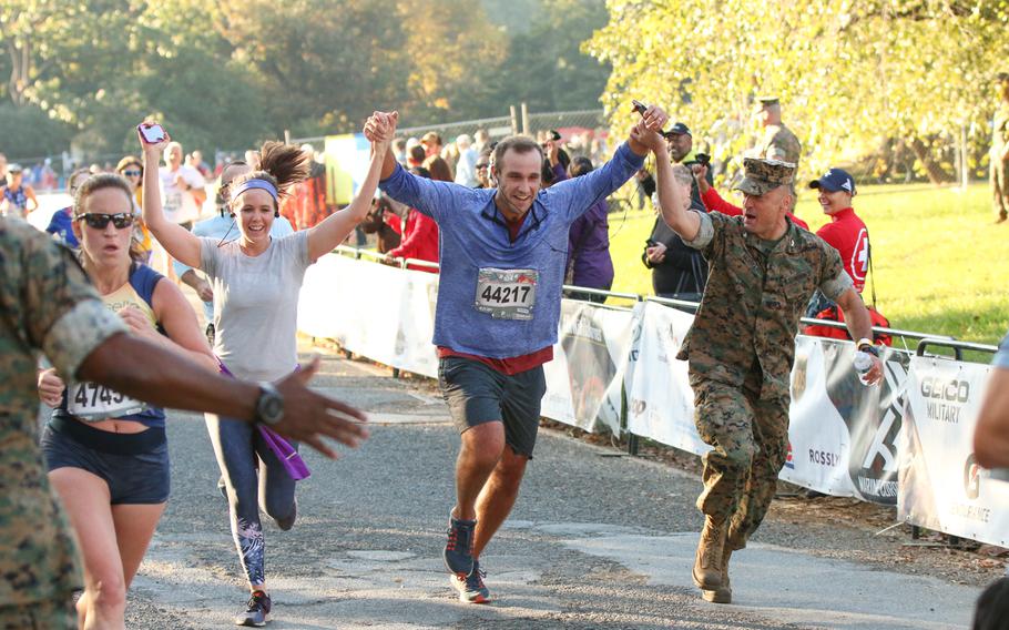 Runners partaking in the 10k run event as part of the overall 42nd Marine Corps Marathon festivities cross the finish line on Oct. 22, 2017.