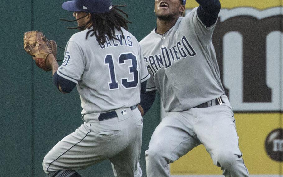 With shortstop Freddy Galvis looming right in front of him, San Diego Padres left fielder Franchy Cordero tries to haul in a fly ball off the bat of the Washington Nationals' Bryce Harper in the first inning of a game at Washington, D.C., May 22, 2018. Cordero dropped the ball, and Harper ended up on second base.