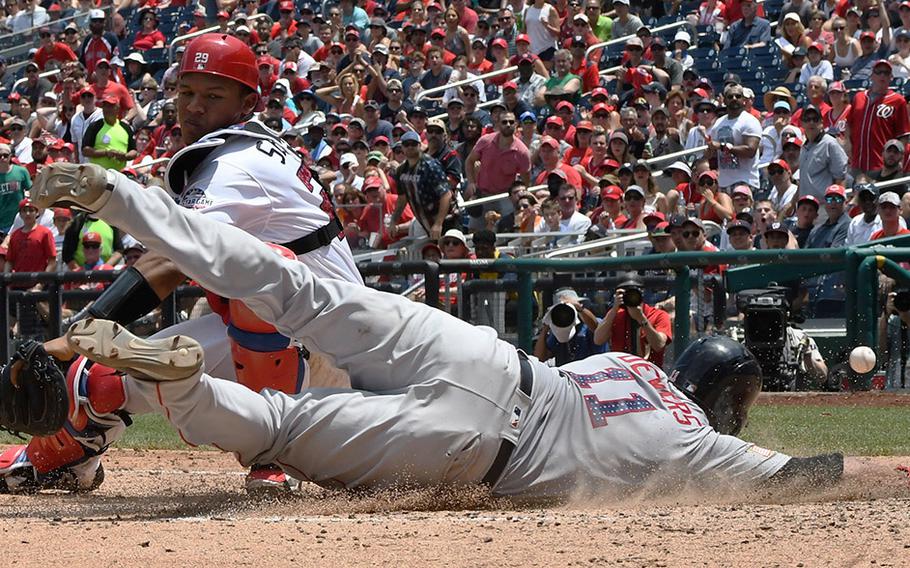 Rafael Devers of the Boston Red Sox scores what would prove to be the winning run on a sacrifice fly as the ball gets away from Washington Nationals catcher Pedro Severino in the seventh inning of a game at Nationals Park in Washington, D.C., July 4, 2018.