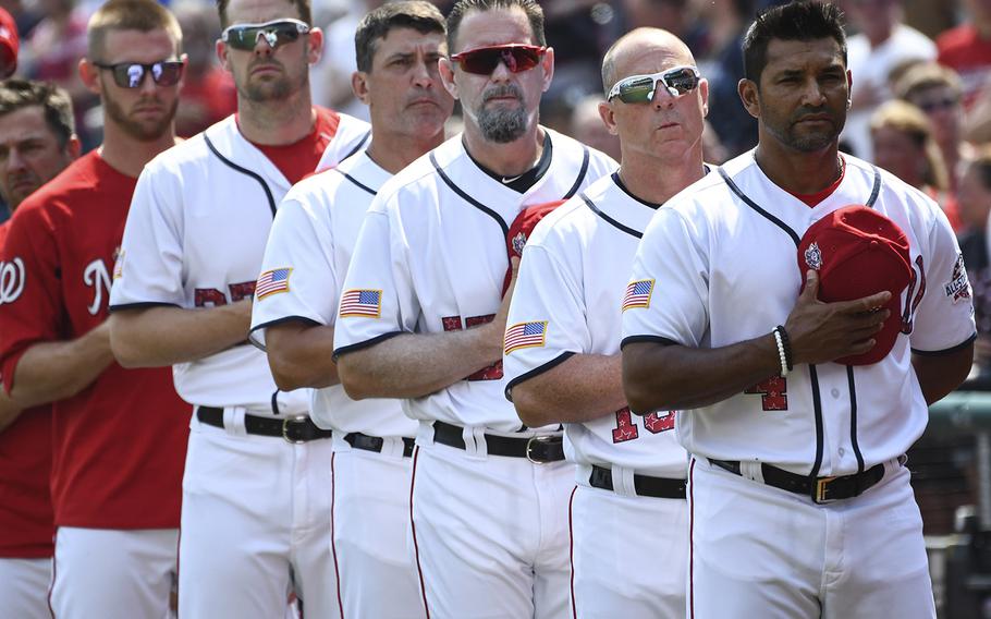 Washington Nationals manager Dave Martinez, right, and his players and coaches stand for the national anthem before a game at Nationals Park in Washington, D.C., July 4, 2018.
