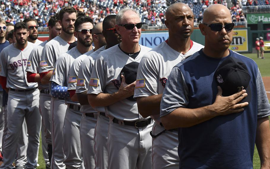 Boston Red Sox manager Alex Cora, right, and his players and coaches stand for the national anthem before a game at Nationals Park in Washington, D.C., July 4, 2018.