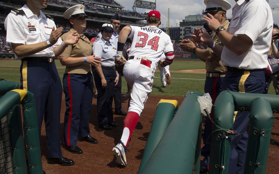 Servicemembers applaud as Bryce Harper and his Washington Nationals teammates take the field for their game against the Boston Red Sox at Nationals Park in Washington, D.C., July 4, 2018.