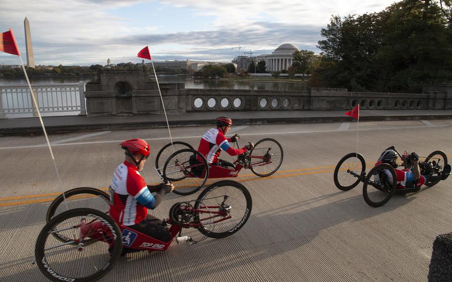 Competitors in the handcrank division of the 43rd Marine Corps Marathon pass two Washington, D.C. landmarks, the Washington Monument and the Jefferson Memorial, near the 12-mile mark on Oct. 28, 2018.