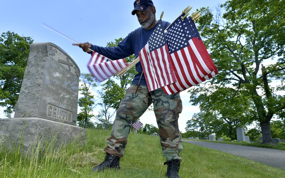 Retired Marine Gunnery Sgt. Bob Workman of Boston, the past commander of the Boston Police VFW, replaces flags at veteran’s graves ahead of Memorial Day on May 27, 2021, in the Fairview Cemetery in Boston. The Department of Veterans Affairs announced the agency will host public Memorial Day ceremonies throughout the United States for the first time in two years since the coronavirus pandemic began.