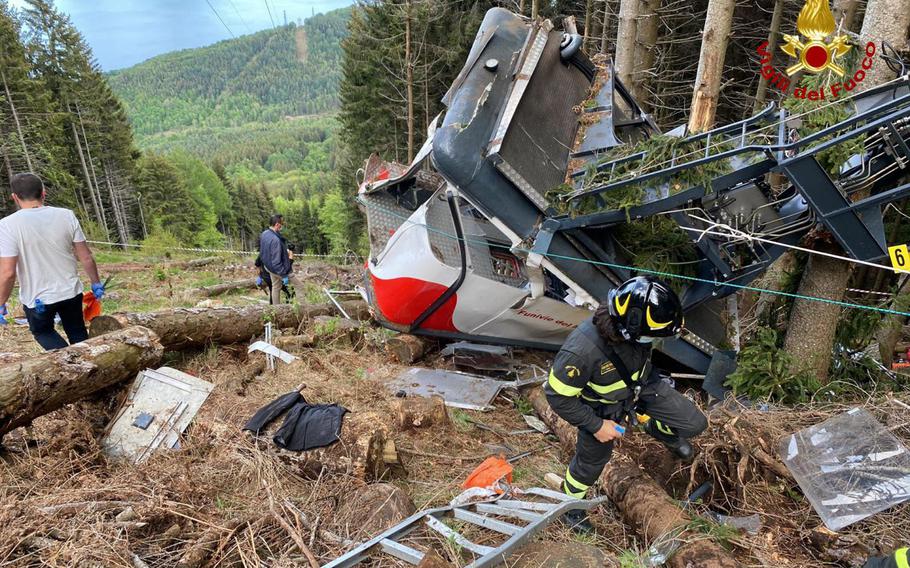 Rescuers work by the wreckage of a cable car after it collapsed near the summit of the Stresa-Mottarone line in the Piedmont region, northern Italy, Sunday, May 23, 2021.  