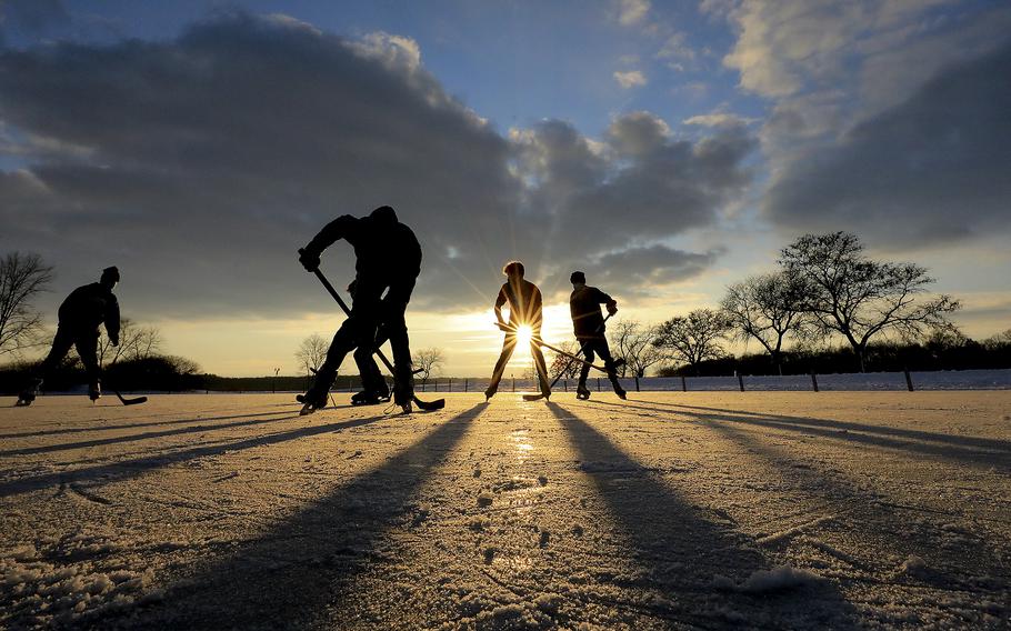 With sub-freezing temperatures taking hold in the region, a group of young hockey enthusiasts enjoy one of their first outings on the ice during a late afternoon visit to Vilas Park in Madison Wis. Thursday, Dec. 17, 2020. (John Hart/Wisconsin State Journal via AP)