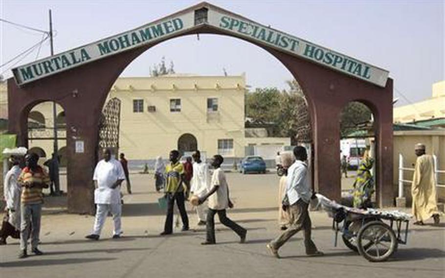 People walk past the entrance gate of the Murtala Mohammed specialist hospital in Kano, were victims of a suicide bombing receive treatment Jan. 23, 2012, following recent sectarian attacks. The emir of Kano and the state's top politician offered prayers for the more than 150 people who were killed in a coordinated series of attacks by the radical Islamist sect called Boko Haram, which means Western education is sacrilege, in the Hausa language of Nigeria's north.