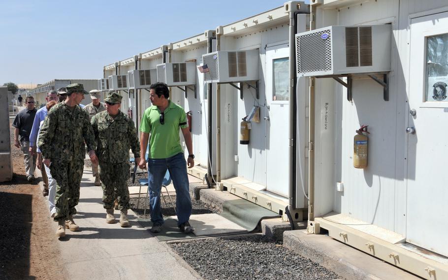 Adm. Jonathan W. Greenert, chief of naval operations, and then-commanding officer of Camp Lemonnier Capt. Kevin Bertelsen walk with Billeting Supervisor Carlos Garces on a tour of the camp living quarters last year. The base has been the site of regular protests recently by workers angry over layoffs.