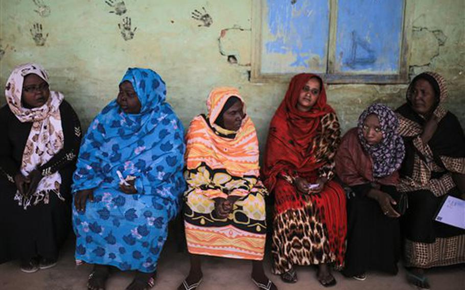 Sudanese women wait to vote outside a polling station Monday, April 13, 2015, on the first day of Sudan's presidential and legislative elections, in Izba, an impoverished neighborhood on the outskirts of Khartoum, Sudan. 