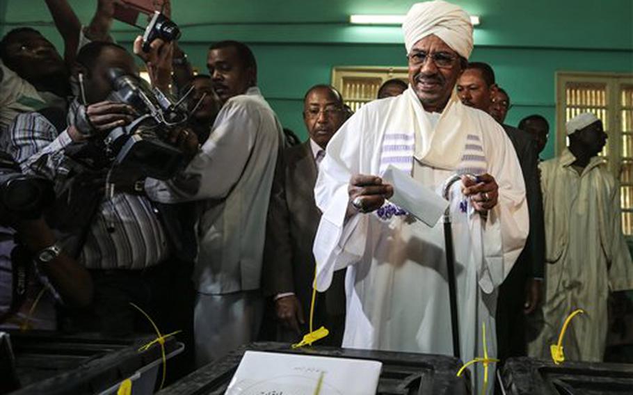 President Omar al-Bashir casts his ballot on the first day of the presidential and legislative elections in Khartoum, Sudan, Monday, April 13, 2015. Al-Bashir, who has ruled Sudan unchallenged for 25 years, is running for another term.
