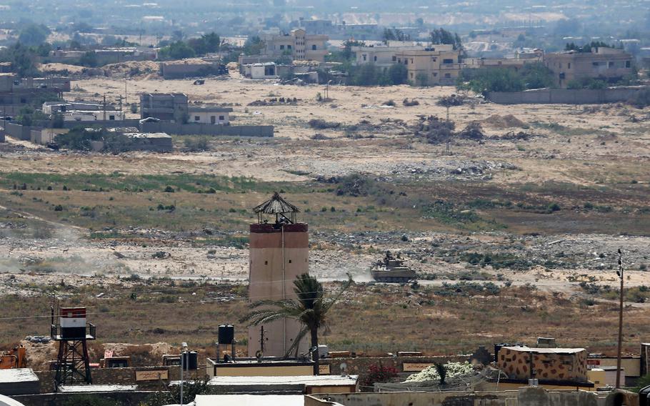 In this July 2, 2015, file photo, an Egyptian armored vehicle patrols next to a military watch tower on the Egyptian side of the border, seen from the south of the Gaza Strip. The Obama administration is quietly reviewing the future of America's 3-decade deployment to the Sinai Peninsula, fearful the lightly equipped peacekeepers could be targets of escalating Islamic State-inspired violence.