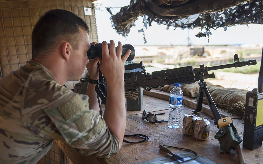 A U.S. soldier assigned to Task Force Guardian, 41st Infantry Brigade Combat Team (IBCT), 1-186th Infantry Battalion, Oregon National Guard, uses binoculars to scan the horizon while on security watch in Somalia, on December 3, 2019.