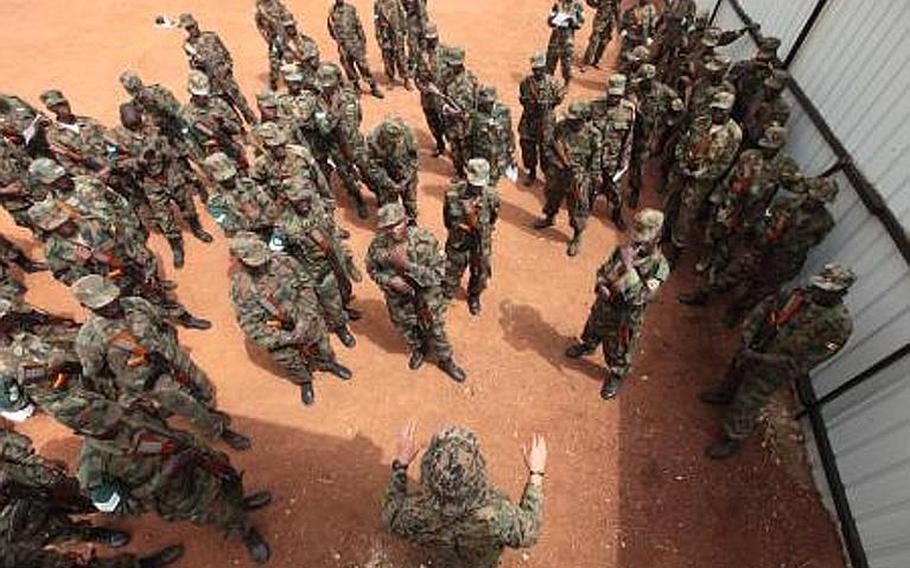 A force reconnaissance Marine goes over threat detection methods with a group of Ugandan soldiers. Special Purpose Marine Air Ground Task Force 12 sent a small team of Marines into Uganda in February to train Ugandan forces for the fight against al-Shabaab in Somalia and the hunt for the Lord's Resistance Army in central Africa.