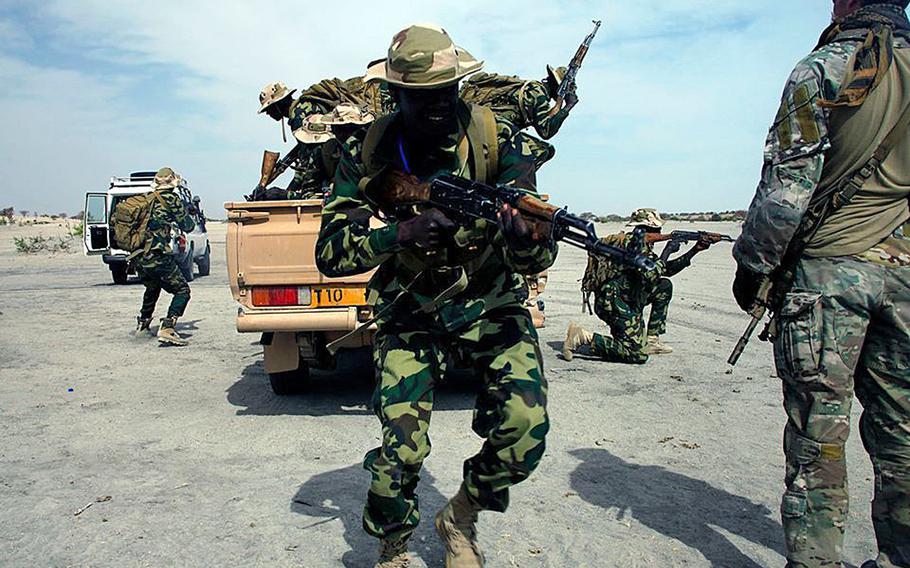 A U.S. Army soldier from 10th Special Forces Group (Airborne) at Fort Carson, Colo., observes as a Chadian platoon practices mounted operations during Exercise Flintlock '15 at Moussoro, Chad, Feb. 19, 2015.