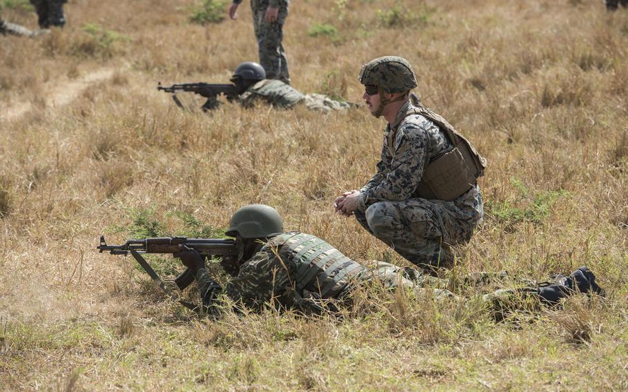 U.S. Marine Corps Cpl. Preston Sidwell assists a Uganda Peoples' Defence Force soldier practicing ground maneuvers during infantry training conducted by Marines at Camp Singo, Uganda, in February 2018.